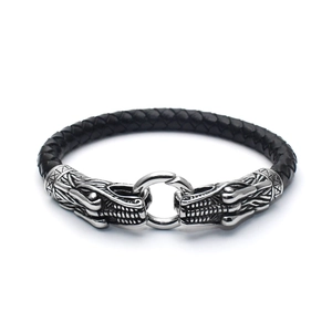 Detail of silver dragon heads and black braided leather strap on a men's bracelet