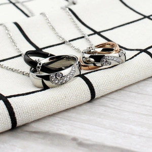Detailed close-up of interlocking heart couple necklaces with sparkling zircon inlay