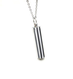 Gros plan détaillé d'un pendentif cylindrique en argent poli avec chaîne en acier