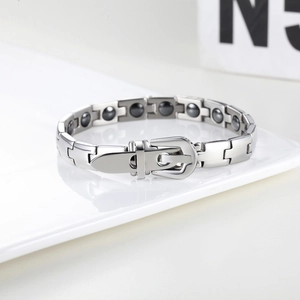 Macro detail of men's magnetic steel bracelet showing buckle clasp and health stones