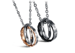 Détail du collier couple entrelacé avec anneaux facettés et pierres de cristal sur chaîne
