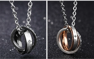 Macro detail of interlocking titanium rings with eternal love engraving and zircon inlay
