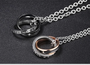 Macro shot of interlocking double rings with Eternal Love engraving in steel and rose gold