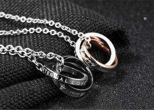 Macro shot of interlocking titanium steel rings with Eternal Love and Forever engraving