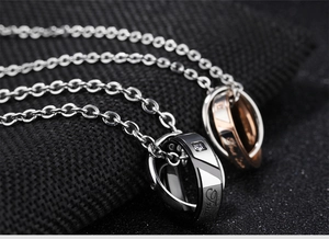 Macro shot of interlocking couple necklaces with True Love engraving and small crystals