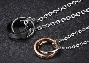 Macro detail of interlocked rings engraved with True Love on titanium steel necklaces