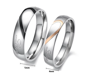 Close-up of 5mm and 4mm stainless steel couple rings showing Love engraving and heart pattern