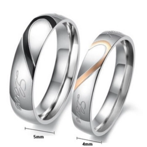 Titanium steel couple rings set with black heart design and Love engraving on white background