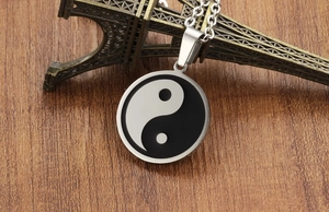 Detailed close-up of a stainless steel Yin Yang pendant with black and white enamel