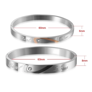 Detail showing Real Love engraved titanium steel couple bracelets with crystal inlay