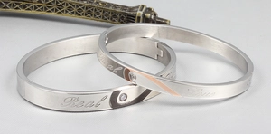 Detailed macro view of silver titanium steel couple bracelets with heart pattern and zircon