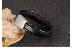 Close-up of black braided leather and smooth band with silver magnetic clasp for men