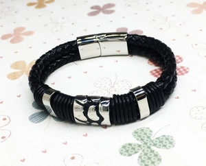 Close-up of a men's punk leather woven bracelet with a polished magnetic metal clasp
