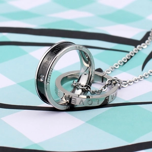 Close-up of titanium steel interlocking rings with rhinestone inlay and engraved text