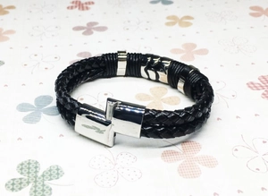 Detail shot of men's double-braided black leather bracelet with silver geometric metal clasp
