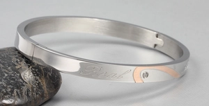 Macro shot of silver titanium steel bangle with Real engraving and rose gold diamond accent