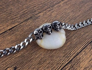 Bracelet punk en acier inoxydable avec trois têtes de mort sur une chaîne gourmette plate