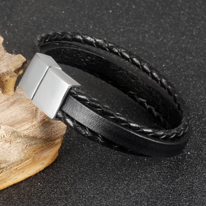 Three-layer braided leather bracelet with brushed silver magnetic clasp on wood