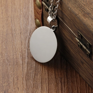 Vintage stainless steel Tai Chi pendant necklace displayed on a rustic wooden jewelry box