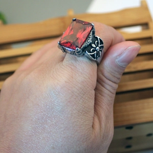 Close-up of a retro gothic titanium steel ring with a large inlaid red gemstone
