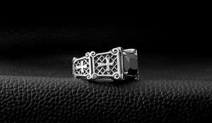 Macro detail of gothic titanium steel ring with square black gemstone and cross engraving