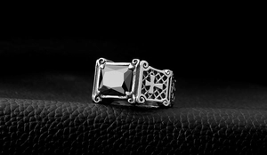 Macro view of vintage gothic steel ring with rectangular black gemstone and cross engraving