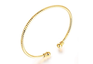 Macro shot of gold-plated bangle featuring diamond-cut facets and round ball ends