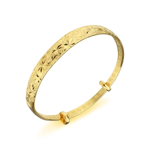 Detailed macro view of 18k gold frosted bangle with star engravings and adjustable clasp