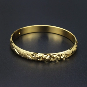 Elegant 18K gold bangle featuring a matte finish and star-shaped geometric cut accents