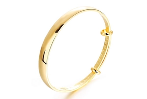 Detail of 18K gold-plated bangle showing internal lucky character carvings and polished finish