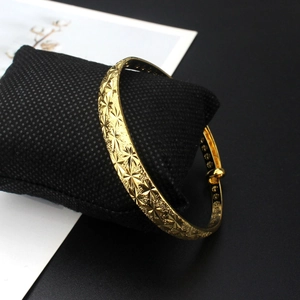 Classic 18k gold adjustable bangle with frosted starry relief on a black cushion