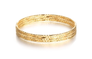 Detailed view of 18K gold-plated textured bangle set with intricate crisscross engraving