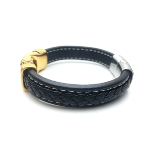 Detail of men's black leather bracelet with white stitching and metal magnetic clasp
