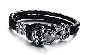Dettaglio di bracciale in pelle punk con teschio d'argento e gemma nera incastonata