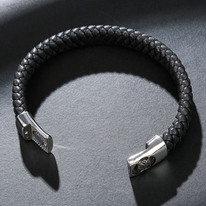 Gros plan d'un bracelet en cuir tressé noir avec fermoir magnétique en métal argenté