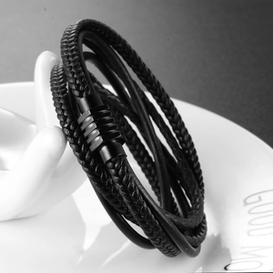 Detail view of multi-layer black braided leather bracelet with matte metal buckle