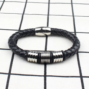 Detail of black woven leather men's bracelet with silver magnetic steel clasp