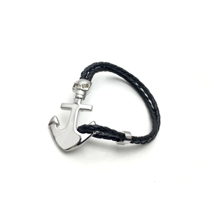 Nahaufnahme von geflochtenem schwarzem Lederarmband mit silbernem Totenkopf-Anker