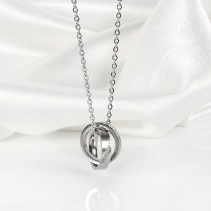 Macro detail of silver interlocking rings necklace featuring polished finish and tiny crystals