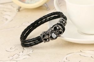 Dettaglio della chiusura a teschio argento vintage con gemma nera su bracciale in pelle