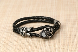 Dettaglio macro del bracciale gotico in pelle a doppio strato con teschio e gemma
