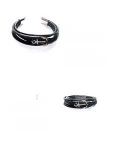 Macro shot of men's multi-layer black woven leather bracelet with silver anchor charm