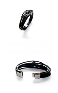 Detail of multi-layer black leather bracelet with silver anchor charm and magnetic clasp