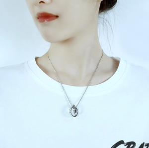 Detailed view of intertwined double ring pendant necklace with LOVE engraving on a model