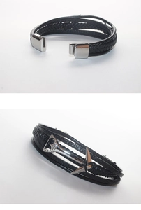 Vue détaillée de l'ancre argentée et du bracelet multicouche en cuir tressé noir