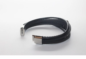 Détail du bracelet multicouche en cuir noir avec un fermoir magnétique en acier argenté