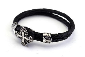 Close-up of double-layered braided black leather bracelet with a silver zircon cross