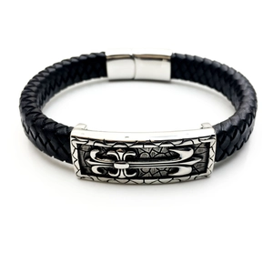 Dettaglio del bracciale in pelle nera intrecciata con croce gotica e chiusura magnetica