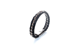 Detail of men's braided black leather bracelet with inset silver beads and polished metal clasp