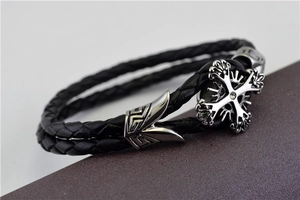 Macro shot of punk black braided leather bracelet with zircon cross pendant and metal detail